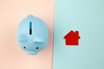 Mortgage concept. Little paper house next to a piggy bank. © burdun