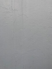 Painted cement wall with uneven surface in grey color