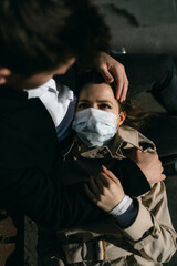 A girl in a medical mask who became ill with coronavirus lies on her husband's lap