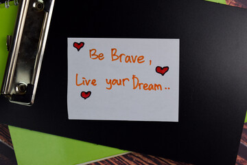Be Brave, Live Your Dream text on sticky notes isolated on office desk.