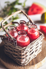 Watermelon juice in jars with a basket with mint leaves and lime citrus