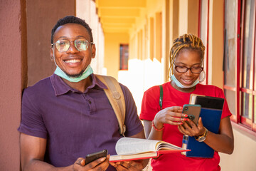 excited african students using their mobile phones