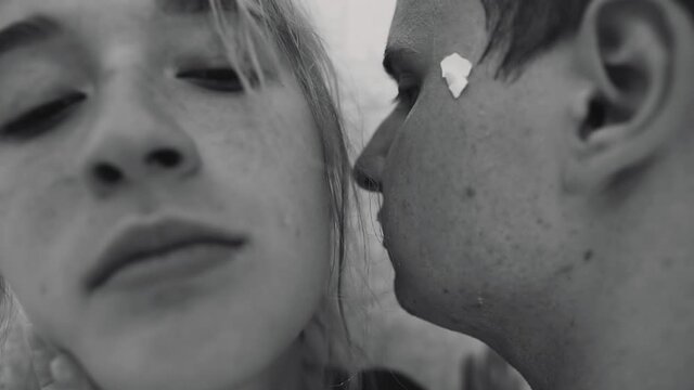 The guy pinned the girl to the wall and whispers something in her ear . The lovers had a fight. Close up