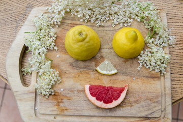 cheerful face composed of lemon, leaves and elderflower