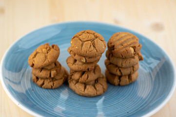 Very tasty peanut butter biscuits on bamboo light brown wooden board, golden baked healthy