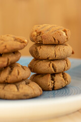 Very tasty peanut butter biscuits on bamboo light brown wooden board, golden baked healthy