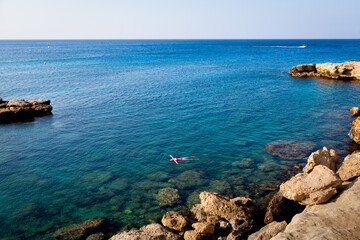 The girl lies on the water in the sea.