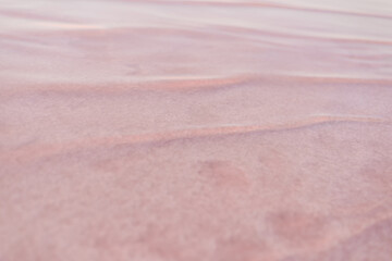 Textured background of the pink lake. Close up of pink salt water. Second Wave concept.