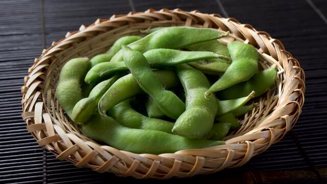 Edamame, a type of bean often eaten as an appetizer or snack in Japanese cuisine. 4K rotating shot.
