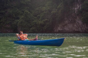 Happy man in a kayak boat on the lake. Relaxing in nature.