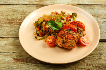 Baked chicken with tomatoes in spices with a side dish of frozen boiled vegetables.