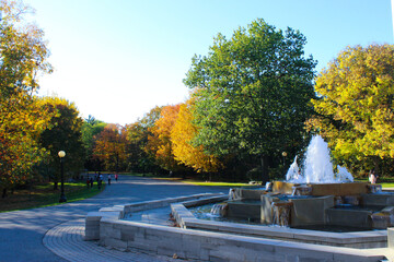 Fountain in the park. A running fountain and around an asphalt road. Visible trees with green and yellow leaves. Park in ottawa, Canada Fall 2012