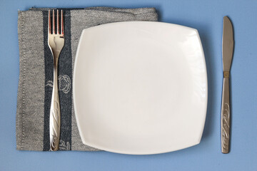 Table setting. Empty plate, knife, fork and napkin. Top view and flat lay with copy space