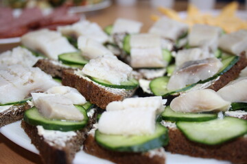 sandwiches with herring and fresh cucumber on black bread