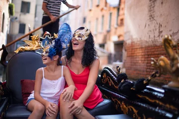 Gordijnen Een moeder heeft plezier met haar dochter op de gondel in Venetië, Italië. Venetiaans masker en familieconcept. © studio GDB