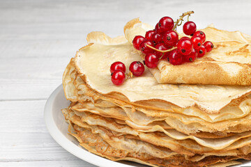 Homemade crepes with barriers on white wooden background. Natural breakfast concept.