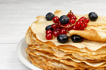 Homemade crepes with barriers on white wooden background. Natural breakfast concept.