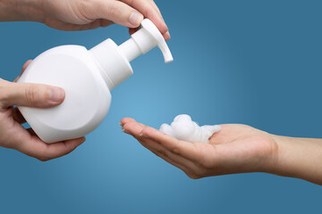 Hand wash and hygiene sanitiser dispensing soap to female hand