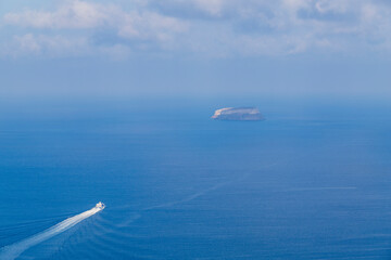 Fototapeta na wymiar View of the sea and coast on the island of Santorini caldera in Greece. The background is a blue sky.