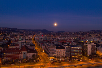 Naklejka premium Aerial drone shot of Church of St. Francis in Buda hill at Budapest dawn with moon