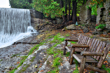 An empty bench at the tourist resort with a waterfall in Caledon, Ontario, Canada.