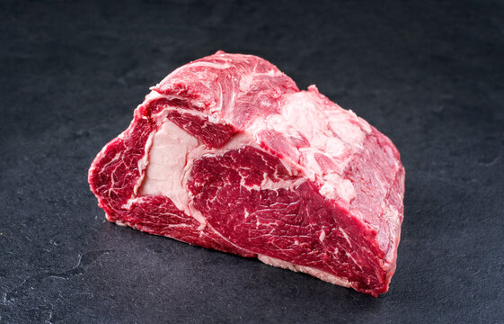 Raw dry aged wagyu Rib-Eye beef steak roast as closeup on a black background with copy space