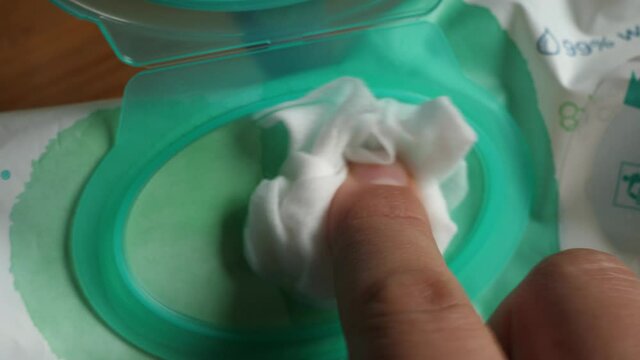 taking take one wet wipe from the packaging