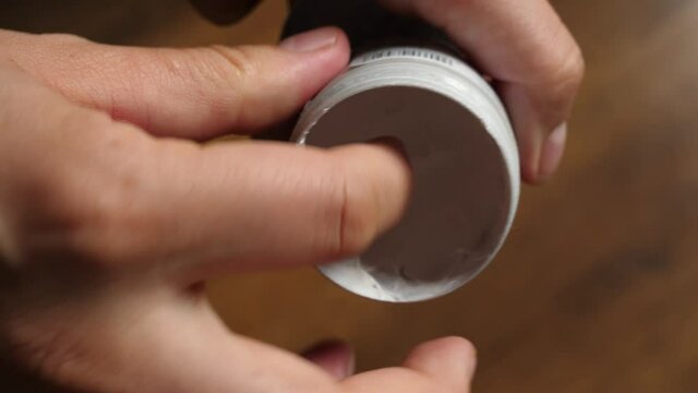 picking up white cream anti-chafing cream on  finger