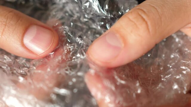 hand under pressure crushes popping the bubble wrap