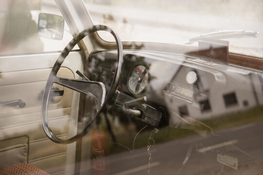 old german car interior of a eastern trabbi with steering wheel and fire extinguisher in cockpit and keys sticking in keyhole