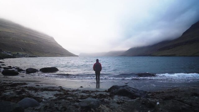 Man Standing At The Coastline Of Funningur