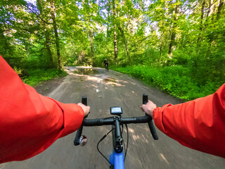 Cyclist on a gravel bike ride in the forest. POV Original point of view.