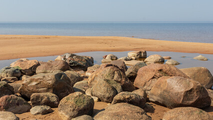 Nice landscape with boulders of different sizes by the sea on a sunny day. Latvia. The rocky coast of Vidzeme