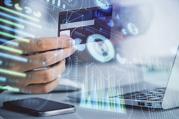 Double exposure of woman on-line shopping holding a credit card and data theme hologram drawing. E-commerce concept.