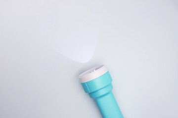 Blue light with beam top view photo on white background. Isolated pocket lightning equipment for...