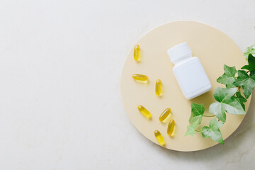 Fish oil vitamin capsules on light table background, top view