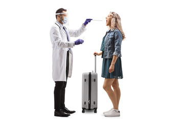 Male doctor with face shield taking a cotton swab test from a female tourist