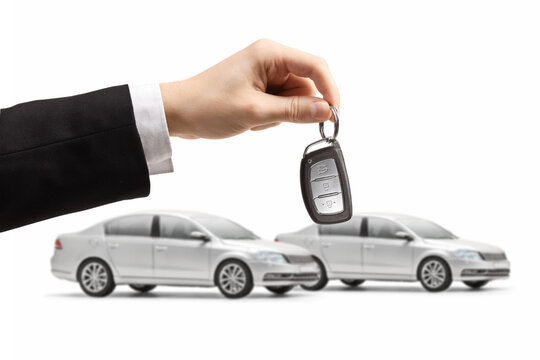 Two identical silver cars and a male hand holding a key