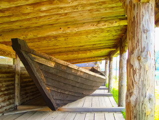 vintage wooden boats under a canopy of round lumber