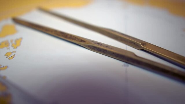 Plotting position on navigational chart at sea. Marine Map and ruler. Sowmotion shot