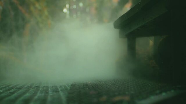 Steam rising up out of under walkway iron grille at city alleyway. Steam pressure from public sewer.