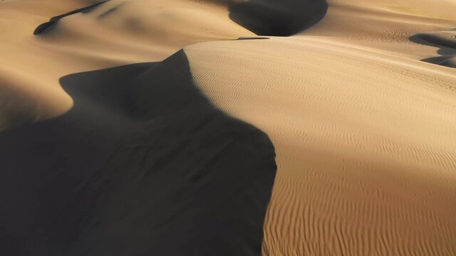 Aerial of the desert nature at sunset. Flying on a plane over the sand dunes is one of the most popular tourist attractions. Beautiful landscape of the California Desert under the wing of the aircraft