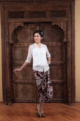 Beautiful woman wearing an elegant kebaya, kebaya is a traditional dress worn by Indonesian and Malaysian women made from gauze cloth worn with batik.