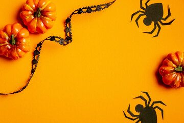 Halloween background with pumpkins, spiders and black ribbon. Flat lay, top view. Happy Halloween concept.