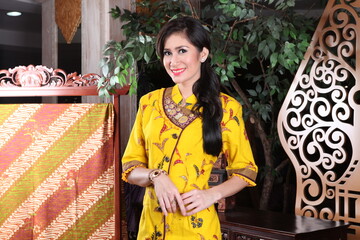 Fototapeta premium Beautiful woman wearing an elegant batik dress, Batik is a fabric that is painted using canting and liquid wax night so as to form paintings of high artistic value from Indonesia