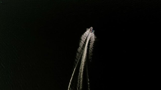Drone looking down on pleasure craft as it swerves on the water