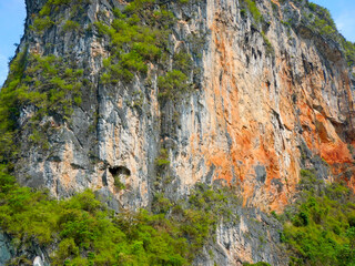 Towering orange limestone cliffs of Railay near Krabi attract rock climbers.