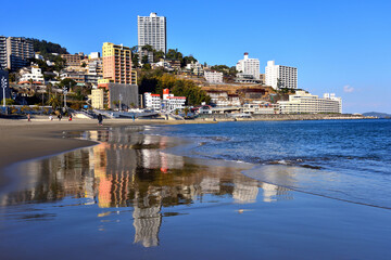 Fototapeta premium 熱海のビーチに映り込む丘陵に建つマンション群