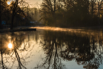 A morning view of Avalon park and preserve, Stony Brook, New York,  with beautiful reflection , sun rays and mist on the water surface © Jay