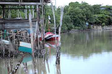 Small fishing boat tethered to a home made landing on a river